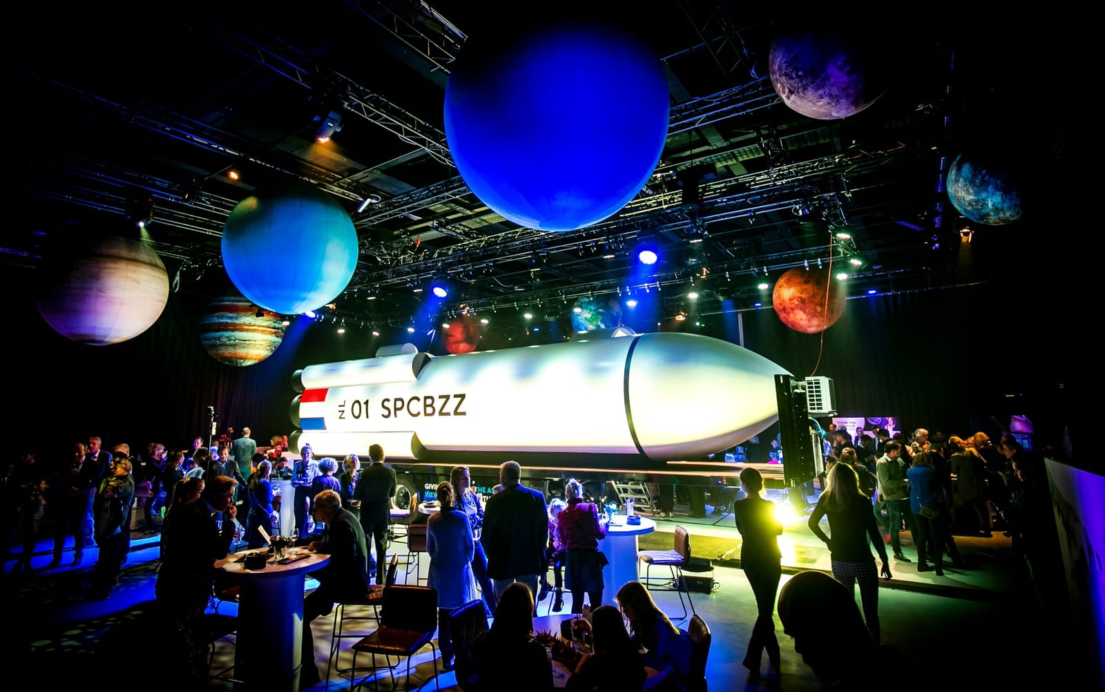 De SpaceBuzz-raket op een trailer, onder opgehangen planeten